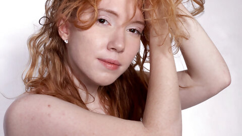 Petite curly haired redhead Nicki Blue flaunts her bush on a fitness ball